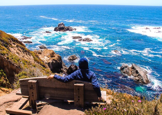 Foto vista de alto ángulo de personas sentadas en un banco en la playa