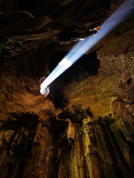 Foto vista de alto ángulo del rayo de sol a través de la formación rocosa en la cueva