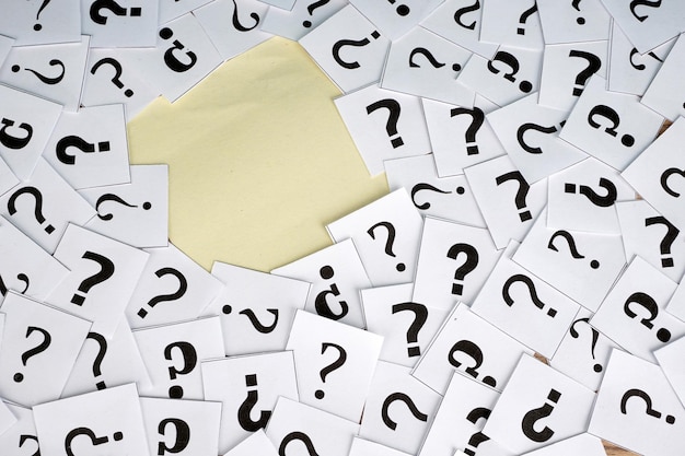 Vista en alto ángulo de los signos de interrogación en las notas adhesivas en la mesa