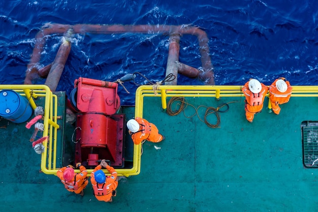 Vista de alto ángulo de los trabajadores de pie en un barco en el mar