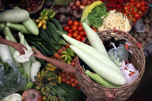 Foto vista de alto ángulo del vendedor que lleva verduras por encima de la cabeza en el mercado