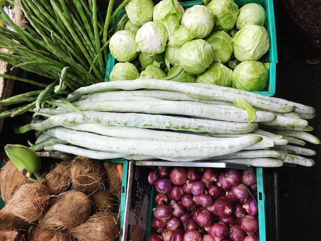 Vista de alto ángulo de verduras y cocos en cajas para la venta