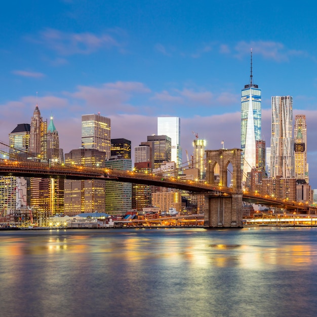 Vista del amanecer del puente de Brooklyn y el horizonte del Bajo Manhattan en la ciudad de Nueva York con iluminación de la ciudad EE.UU.