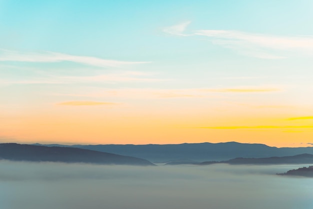 Vista del amanecer sobre la niebla de las montañas en el paisaje inferior