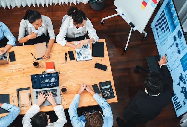 Foto vista ampla de cima de um grupo diversificado de equipe de analistas de negócios analisando dados financeiros relatório de papel na mesa de reunião gráfico e painel de gráficos por análise de inteligência de negócios meticuloso