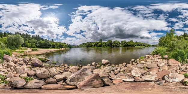 Vista de ángulo de 360 grados de panorama hdri esférico completo en la costa rocosa de un río enorme en un día soleado de verano y clima ventoso con hermosas nubes en contenido de realidad virtual de proyección equirectangular