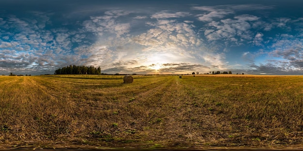 Vista de ángulo de 360 grados de panorama hdri esférico completo sin costuras entre campos en la puesta de sol de la tarde de verano con hermosas nubes en proyección equirectangular