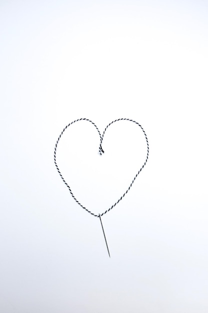 Foto vista de ángulo alto de un alfiler con hilo en forma de corazón s proyecto diy