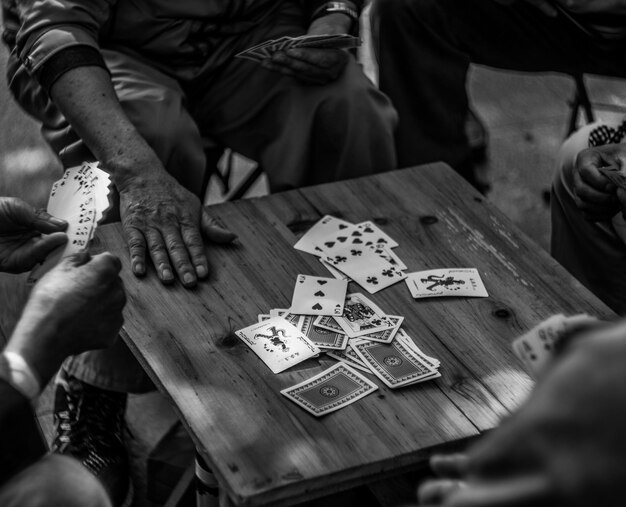 Foto vista de ángulo alto de amigos jugando a las cartas en la mesa