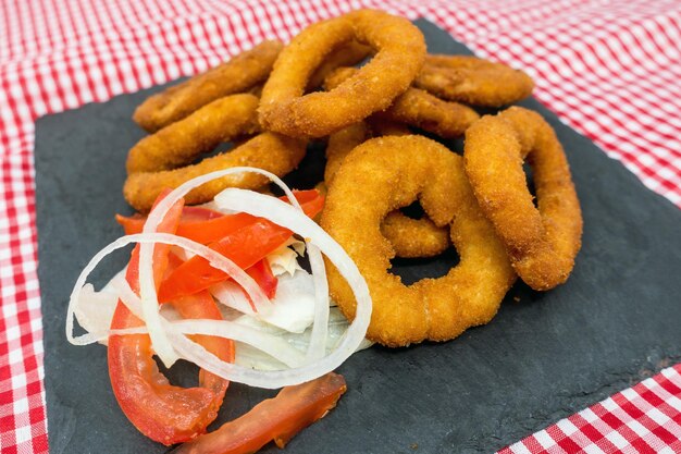 Foto vista de ángulo alto de anillos de cebolla frita y ensalada en el plato sobre la servilleta