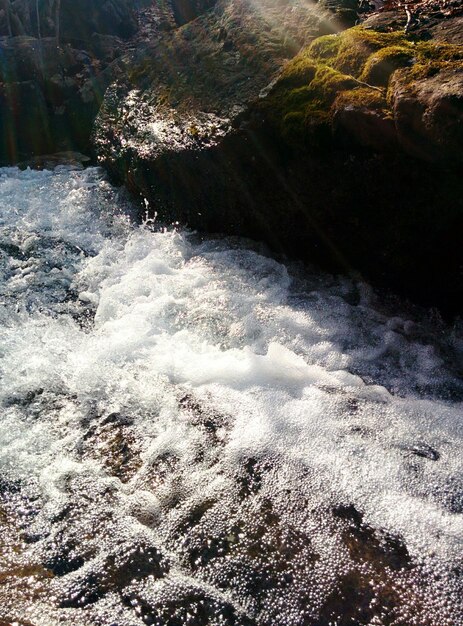 Foto vista de ángulo alto de un arroyo que fluye por la roca