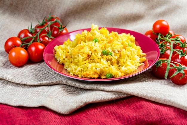 Foto vista de ángulo alto de arroz frito con tomates en un plato de yute