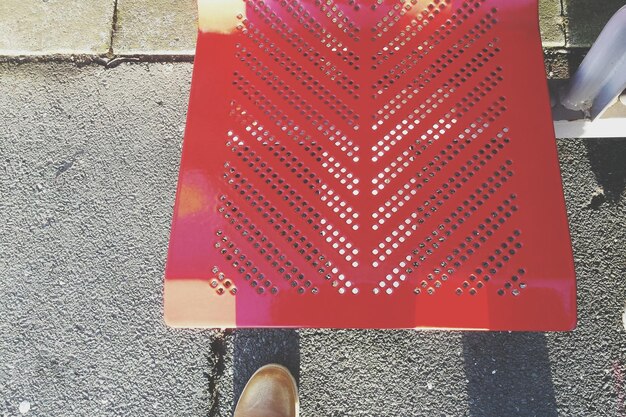 Foto vista de ángulo alto de un asiento rojo vacío en la plataforma de la estación de tren