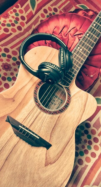 Foto vista de ángulo alto de los auriculares en la guitarra