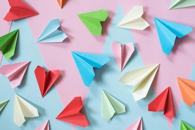 Vista de ángulo alto de un avión de papel multicolor en la mesa