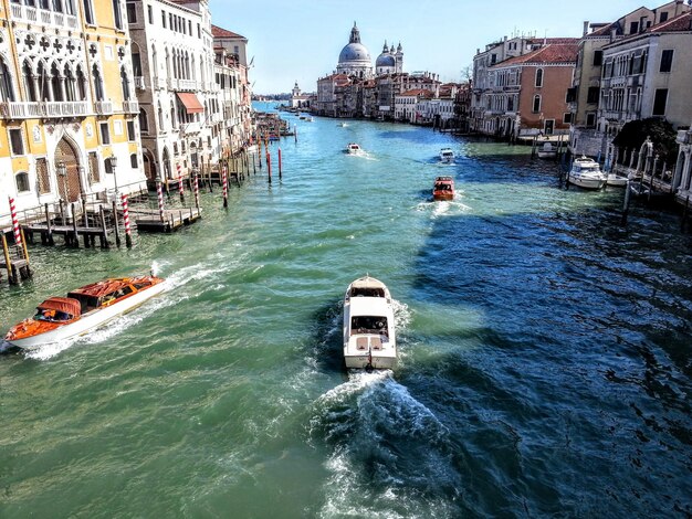 Vista de ángulo alto de un barco navegando en el canal en medio de los edificios