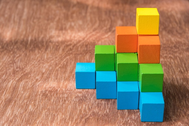 Vista de ángulo alto de bloques de juguete multicolores en una mesa de madera