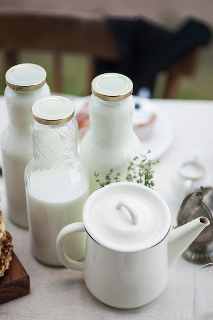 Foto vista de ángulo alto de botellas de leche y tetera en la mesa