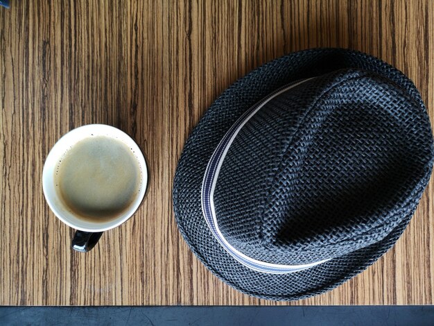 Foto vista de ángulo alto del café y el sombrero en la mesa