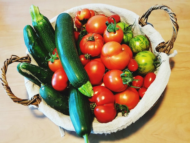 Vista de ángulo alto de calabazas y tomates en la canasta
