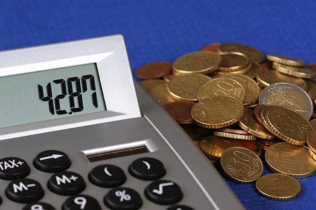 Vista de ángulo alto de la calculadora y las monedas en la mesa