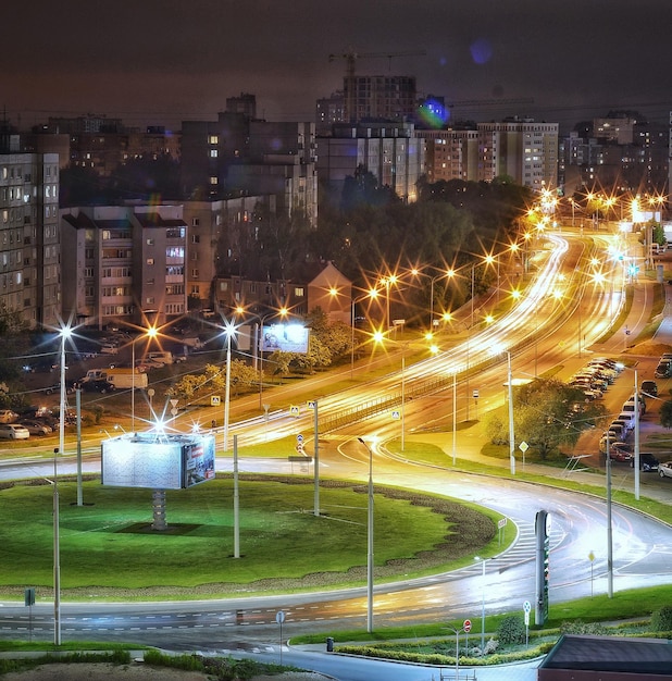 Foto vista de ángulo alto de la calle iluminada en medio de los edificios por la noche