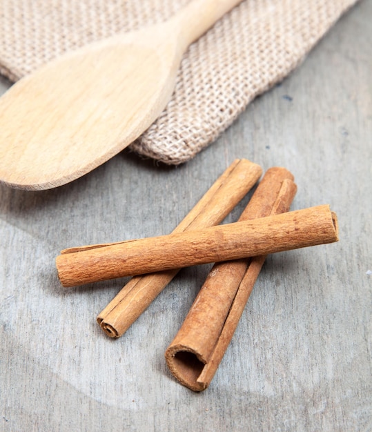 Vista de ángulo alto de canela con saco y espátula de madera en la mesa