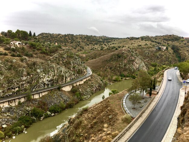 Foto vista de ángulo alto de la carretera por las plantas contra el cielo