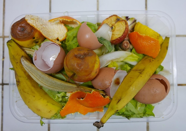 Vista de ángulo alto de la cáscara de los alimentos en el recipiente en el suelo