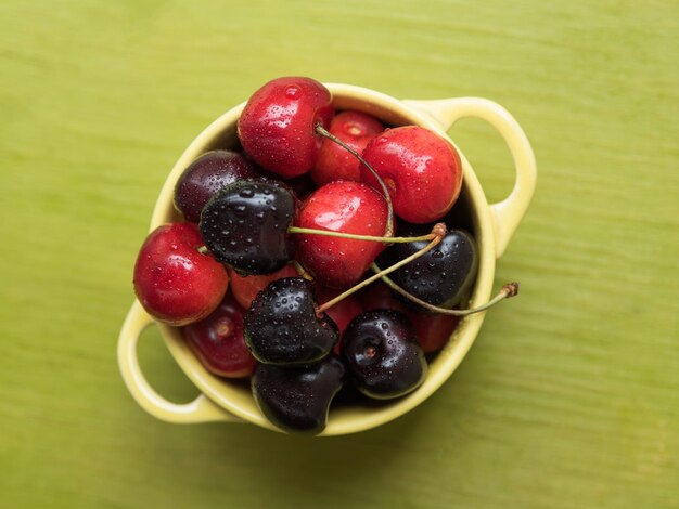 Foto vista de ángulo alto de las cerezas en el cuenco en la mesa