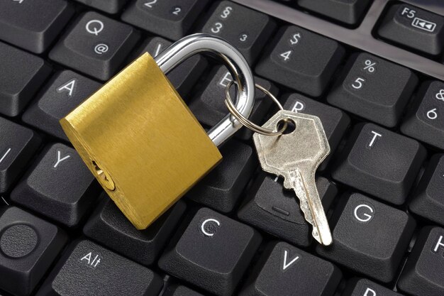 Vista de ángulo alto de la cerradura y la llave en el teclado de la computadora