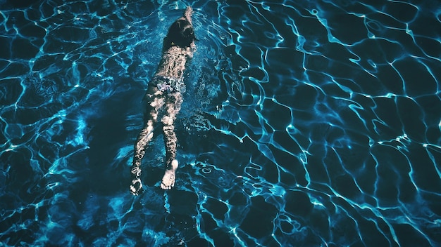 Vista de ángulo alto de una chica nadando en la piscina