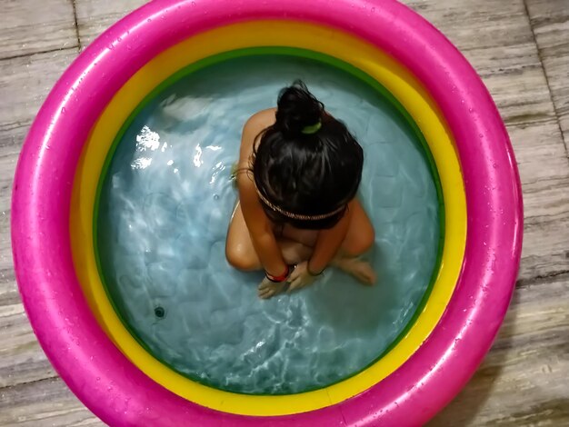 Foto vista de ángulo alto de una chica sentada en una piscina