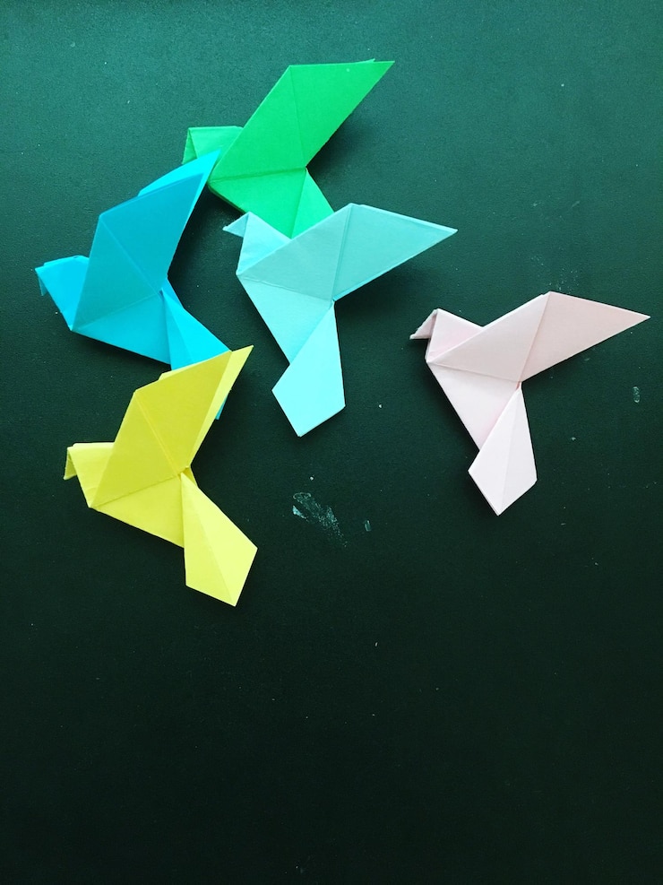 Foto vista de ángulo alto de coloridas grúas de papel en la mesa