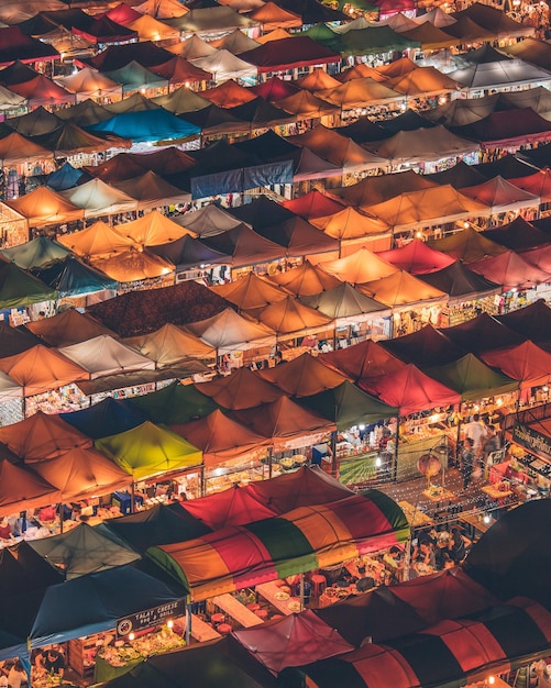 Vista de ángulo alto de coloridas tiendas de campaña en el mercado durante la noche