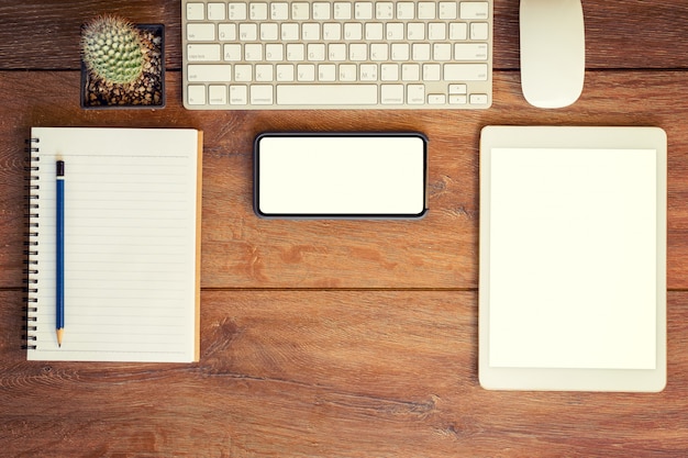 Foto vista de ángulo alto de una computadora de mesa de configuración, teléfono y tableta de lugar de trabajo de negocios.