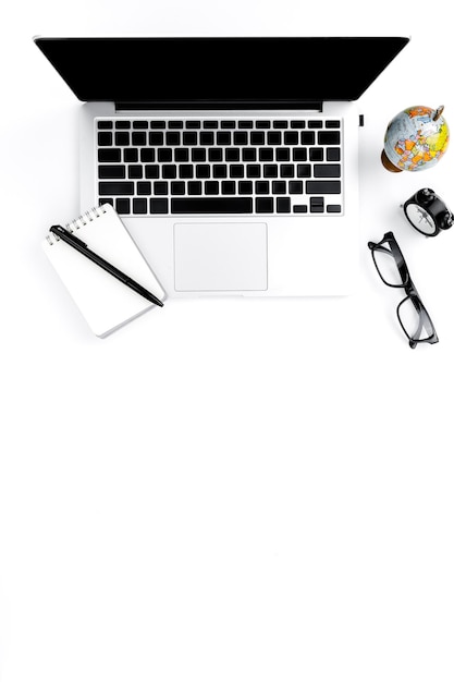 Vista de ángulo alto de la computadora portátil y el bloc de notas contra un fondo blanco