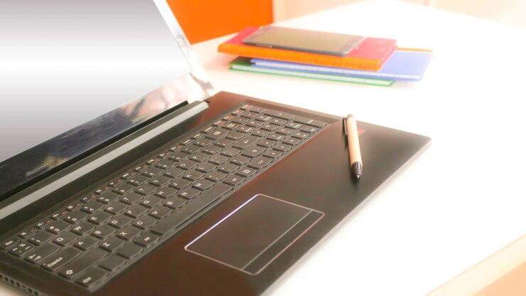 Foto vista de ángulo alto de la computadora portátil con bolígrafo en la mesa