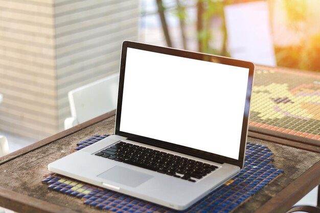 Vista de ángulo alto de una computadora portátil con pantalla en blanco en una cafetería de la acera