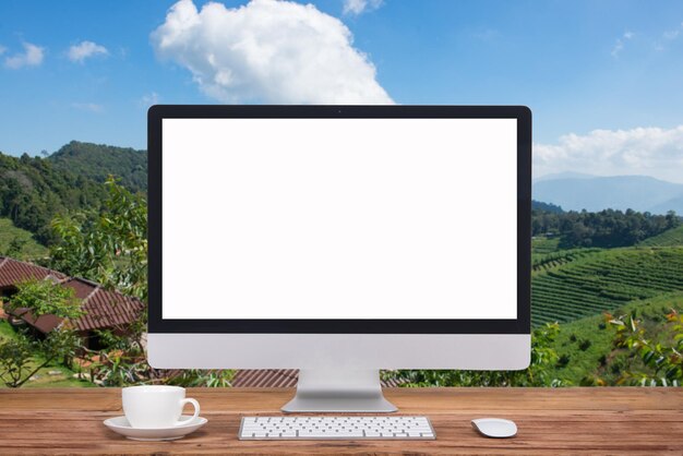 Foto vista de ángulo alto de la computadora portátil por la taza de café en la mesa contra el cielo