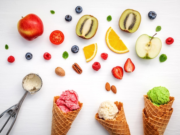 Foto vista de ángulo alto de conos de helado con varias frutas en fondo blanco