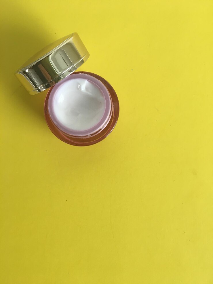 Foto vista de ángulo alto de la crema hidratante sobre un fondo amarillo