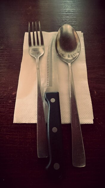 Foto vista de ángulo alto de la cuchara con cuchillo y tenedor de cocina en la mesa