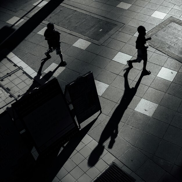 Foto vista de ángulo alto de dos personas caminando por la acera