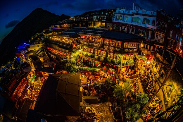 Foto vista de ángulo alto de edificios iluminados en la ciudad por la noche