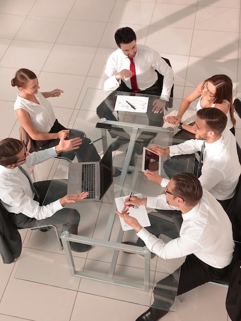 Vista de ángulo alto de empresarios multiétnicos discutiendo en la reunión de la sala de juntas