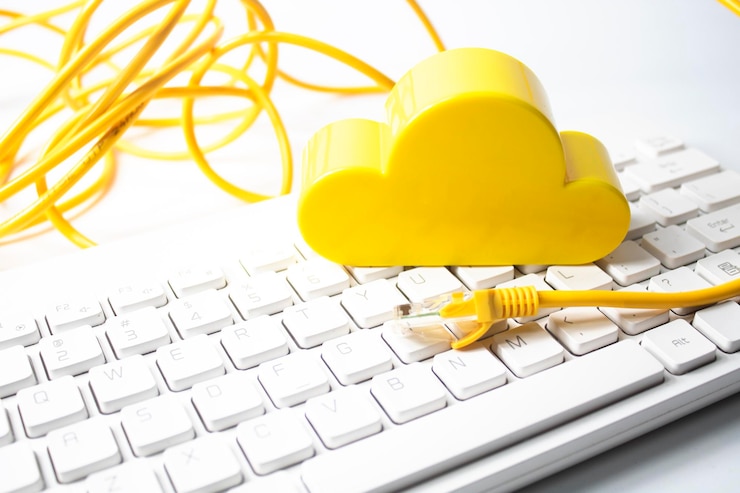 Foto vista de ángulo alto de la estatuilla de la nube en el teclado contra un fondo blanco