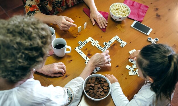 Foto vista de ángulo alto de la familia jugando al dominó en la mesa