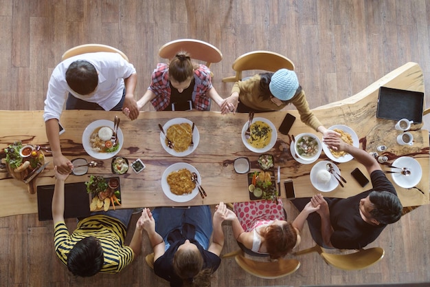 Vista de ángulo alto de la familia orando en la mesa del comedor