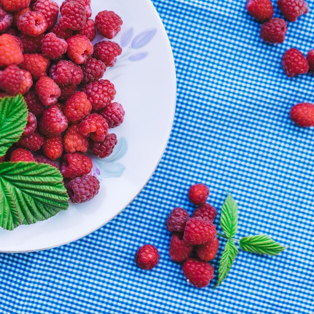 Foto vista de ángulo alto de las frambuesas en el plato sobre la mesa